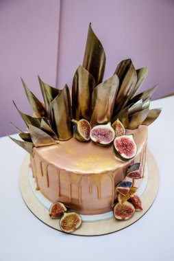 Modaya uygun modern çikolata karamel katmanlı kek çikolata sır, incir ve çikolata dekor ile dekore edilmiş.