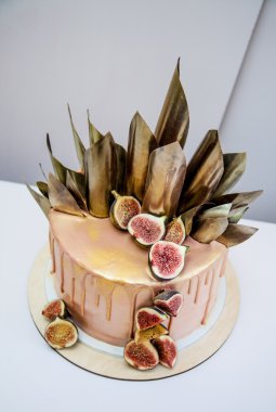 Modaya uygun modern çikolata karamel katmanlı kek çikolata sır, incir ve çikolata dekor ile dekore edilmiştir. Siyah arka plan.