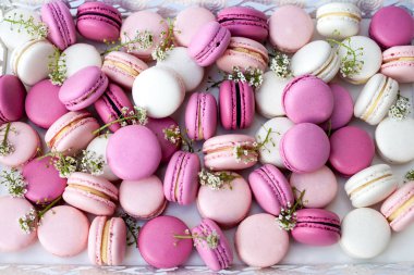 Beyaz tepsi tam renkli macarons pembe tonları. Doğal ışık. Seçici odak.
