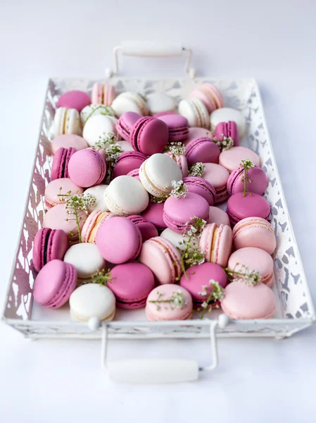 Bandeja blanca llena de coloridos macarons tonos de rosa. Luz natural. Enfoque selectivo . — Foto de Stock