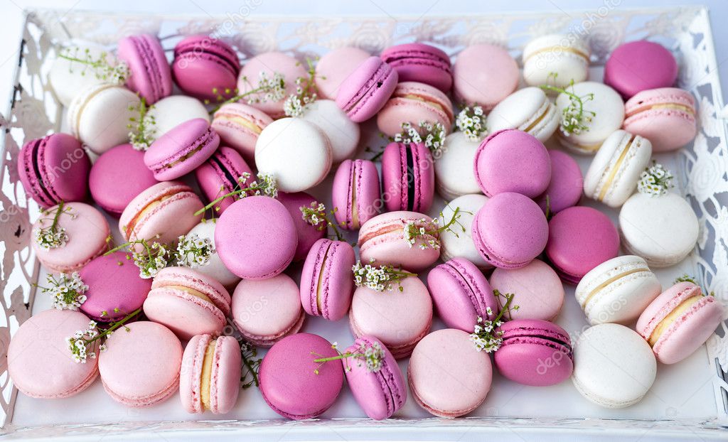 White tray full of colorful macarons shades of pink. Natural light. Selective focus.