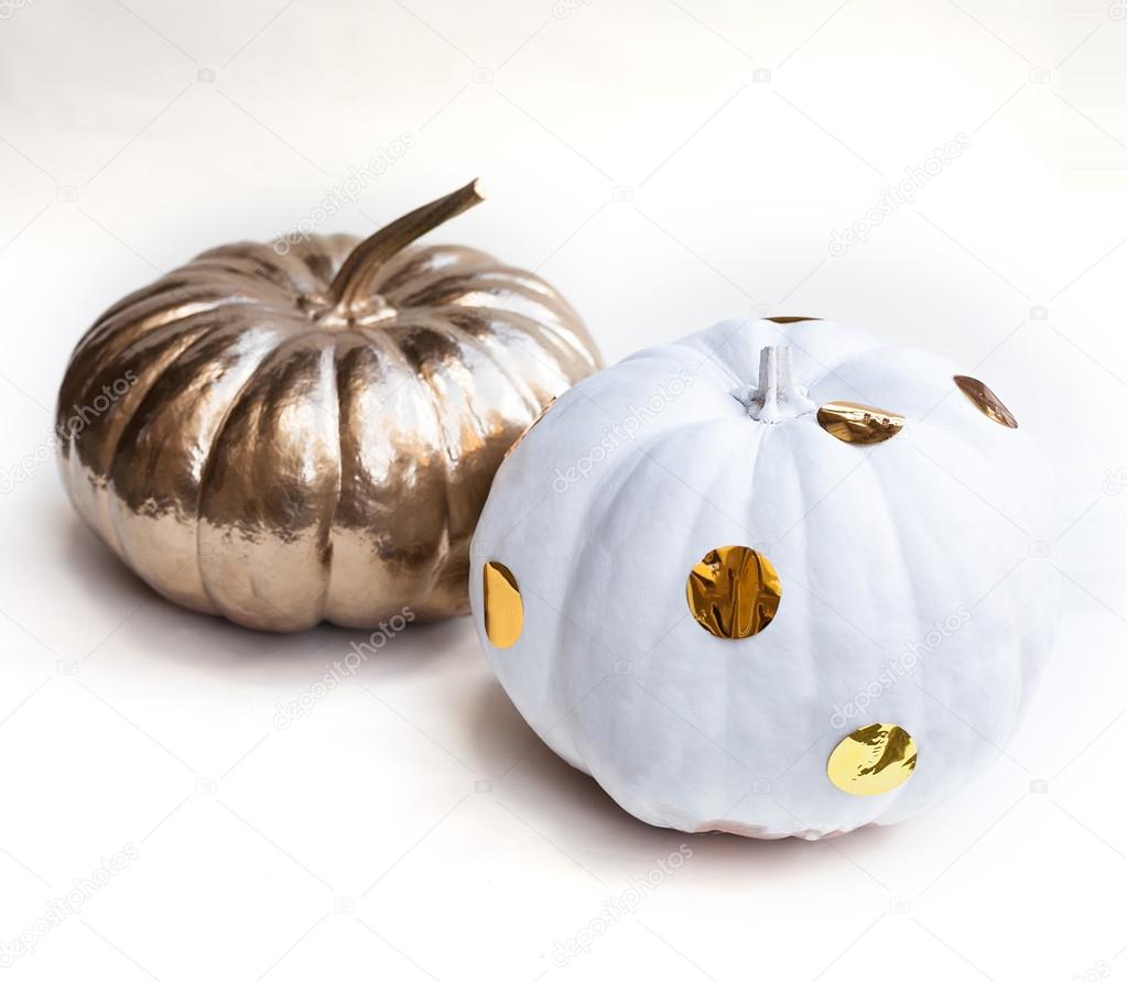 Halloween pumpkin painted in white and gold. Holiday decoration.