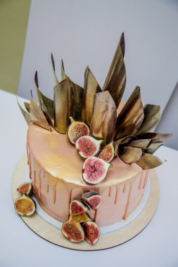 Modaya uygun modern çikolata karamel katmanlı kek çikolata sır, incir ve çikolata dekor ile dekore edilmiş.