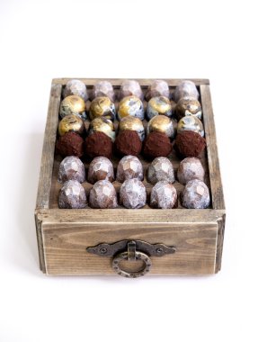 Çikolata el boyalı şeker bonbon bir ahşap kutu üzerinde yapılmış. Beyaz izole. Doğal ışık