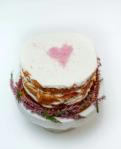 入札の上にピンクのハートと下部にヘザーの花の自家製ケーキのぼろぼろ。白背景 — ストック写真