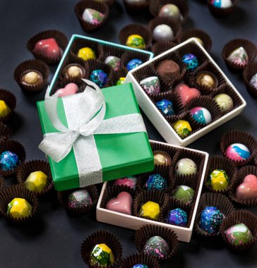 El yapımı çikolata şeker tatlı bir hediye kutuları içinde. Siyah arka plan.