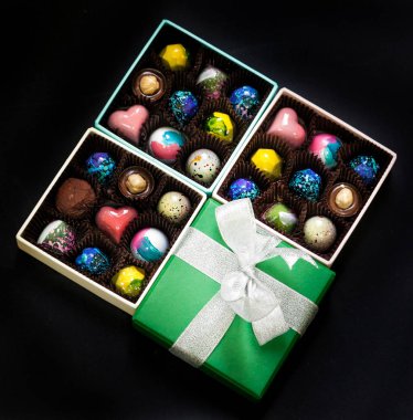 El yapımı çikolata şeker tatlı bir hediye kutuları içinde. Siyah arka plan.