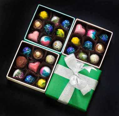 El yapımı çikolata şeker tatlı bir hediye kutuları içinde. Siyah arka plan.