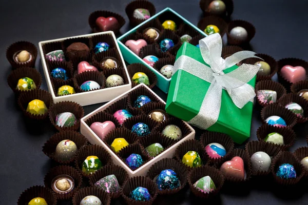 Chocolate handmade candy sweets in a gift boxes. Black background.