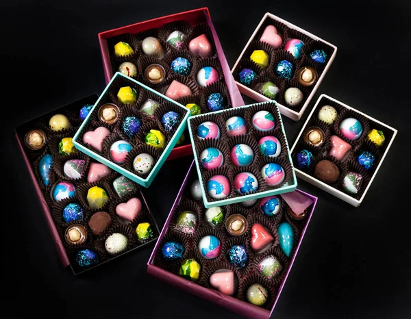 Chocolate handmade candy sweets in a gift boxes. Black background.