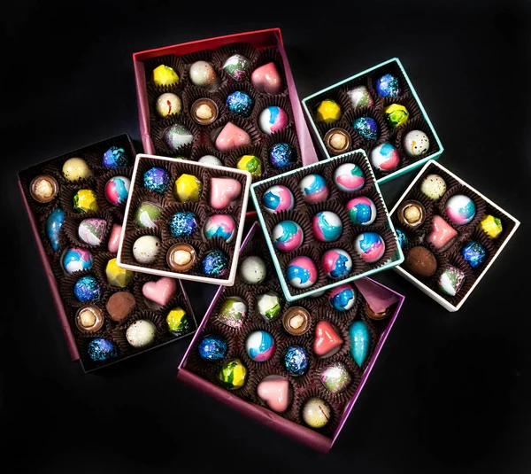 Chocolate handmade candy sweets in a gift boxes. Black background.