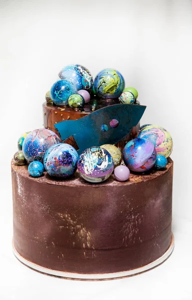 Modern trendy 2-tier layered cake with chocolate hand painted planets and rocket on a white background. — Stock Photo, Image
