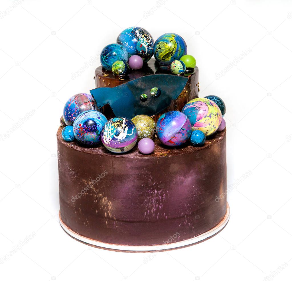 Modern trendy 2-tier layered cake with chocolate hand painted planets and rocket on a white background. 