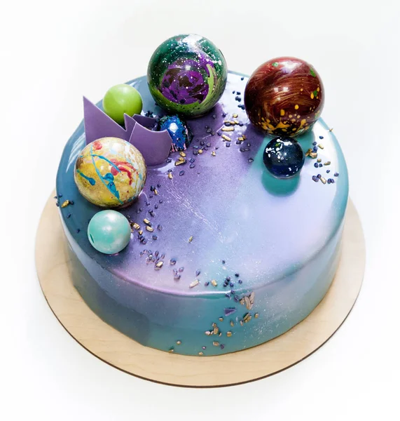 现代时尚慕斯蛋糕与紫蓝色大理石镜面釉在白色背景上。巧克力星球装饰. — 图库照片