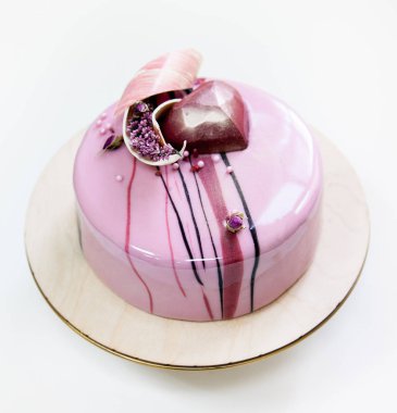 Beyaz bir arka plan ayna sırlıdır minimalist pembe mousse kek ile kaplanmış. Çikolata kalp, çikolatalı girdap ve kuru heather dekor.