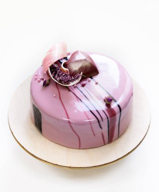 Beyaz bir arka plan ayna sırlıdır minimalist pembe mousse kek ile kaplanmış. Çikolata kalp, çikolatalı girdap ve kuru heather dekor.