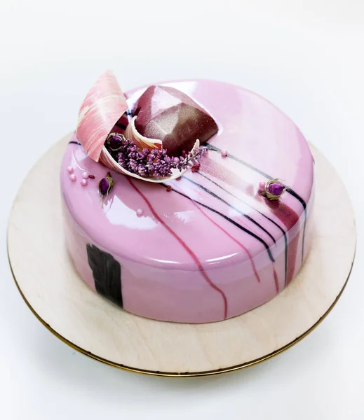 简约的粉红色慕斯蛋糕与涂有白色背景上的镜子釉。心形巧克力，巧克力的漩涡，干石南花装饰. — 图库照片