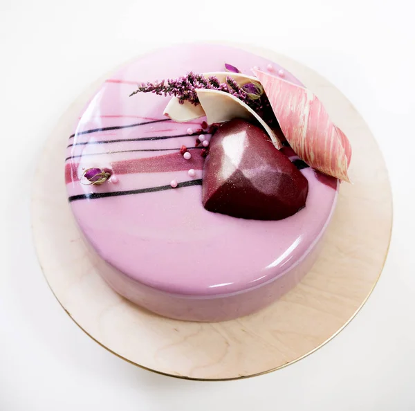 Torta de mousse rosa minimalista con esmalte de espejo sobre fondo blanco. Corazón de chocolate, remolino de chocolate y decoración de brezo seco . — Foto de Stock