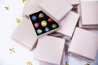 Çikolata el lüks şeker bonbon pembe hediye kutuları içinde boyalı. Altın yıldız ile beyaz arka plan. 
