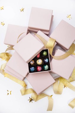 Çikolata el boyalı lüks şeker bonbon pembe bir hediye kutuları ve altın şerit. Altın yıldız ile beyaz arka plan. 