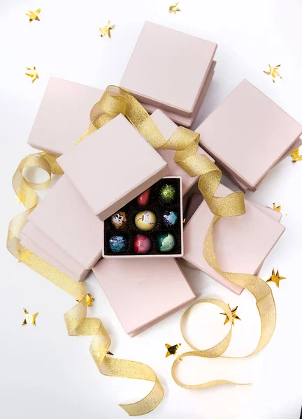 Çikolata el boyalı lüks şeker bonbon pembe bir hediye kutuları ve altın şerit. Altın yıldız ile beyaz arka plan. — Stok fotoğraf