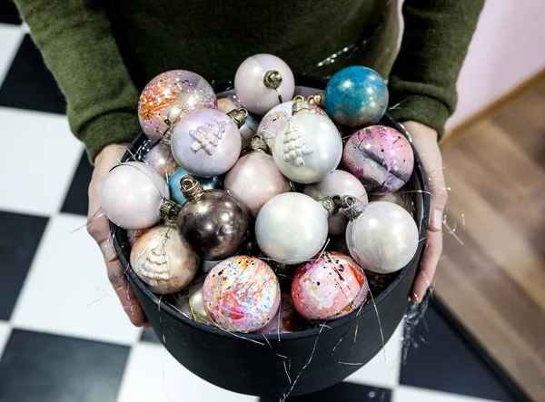 El eller Noel tutan bir siyah hediye kutusu hayalarına boyalı çikolata şeker. — Stok fotoğraf