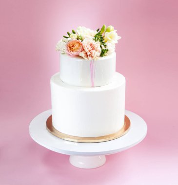 Şık dekore edilmiş taze gül ve Frezya katmanlı pasta düğün