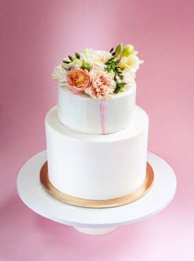 Şık dekore edilmiş taze gül ve Frezya katmanlı pasta düğün