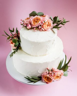 Şık dekore edilmiş taze gül ve Frezya katmanlı pasta düğün