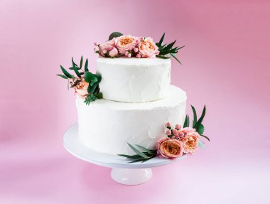 Şık dekore edilmiş taze gül ve Frezya katmanlı pasta düğün