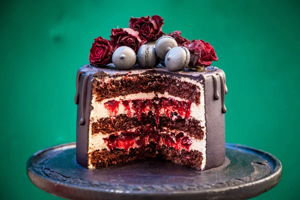 在黑色蛋糕架上片巧克力樱桃蛋糕。木制的绿色背景. — 图库照片