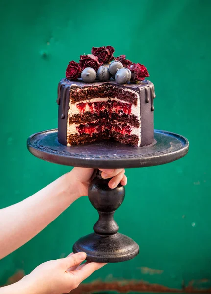 在黑色蛋糕架上片巧克力樱桃蛋糕。木制的绿色背景. — 图库照片