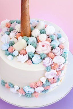 Tek boynuzlu at meringues ile dekore kek katmanlı. Pembe bir arka plan.