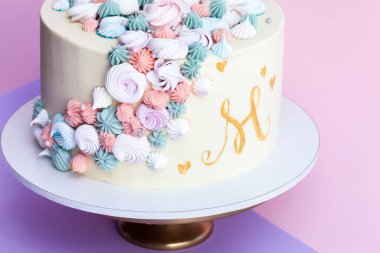 Tek boynuzlu at meringues ile dekore kek katmanlı. Pembe bir arka plan.