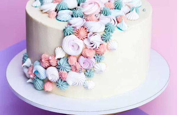 ユニコーンは層のメレンゲで飾られたケーキです。ピンクの背景. — ストック写真