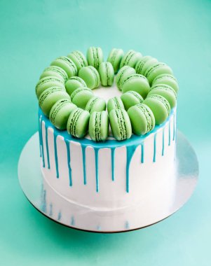 Lezzetli vanilyalı katmanlı pasta yeşil macarons ile dekore edilmiş