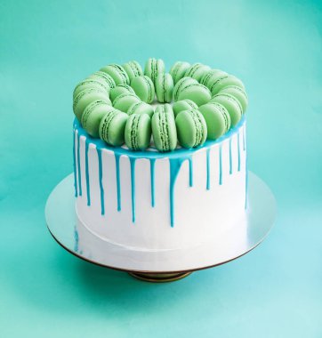 Lezzetli vanilyalı katmanlı pasta yeşil macarons ile dekore edilmiş