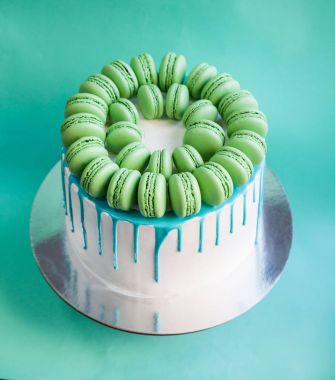 Lezzetli vanilyalı katmanlı pasta yeşil macarons ile dekore edilmiş