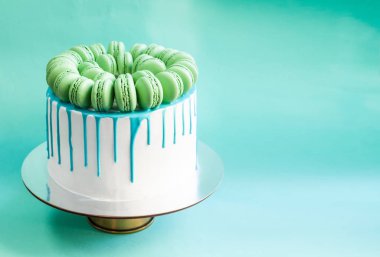 Lezzetli vanilyalı katmanlı pasta yeşil macarons ile dekore edilmiş