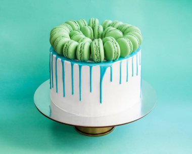 Lezzetli vanilyalı katmanlı pasta yeşil macarons ile dekore edilmiş