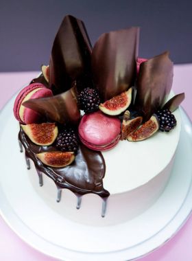 Kek çikolata dalgalar, pembe macaron ve taze incir ile dekore edilmiş