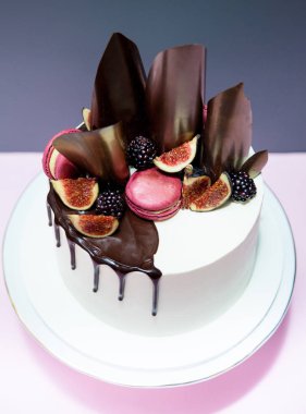 Kek çikolata dalgalar, pembe macaron ve taze incir ile dekore edilmiş