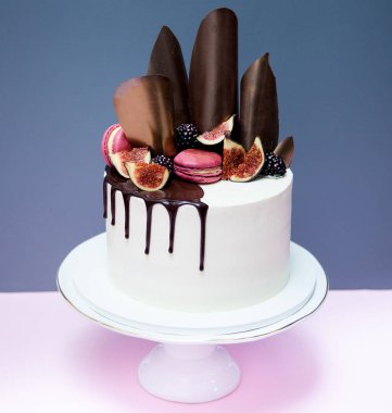 Kek çikolata dalgalar, pembe macaron ve taze incir ile dekore edilmiş