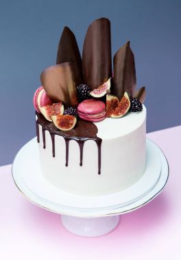 Kek çikolata dalgalar, pembe macaron ve taze incir ile dekore edilmiş