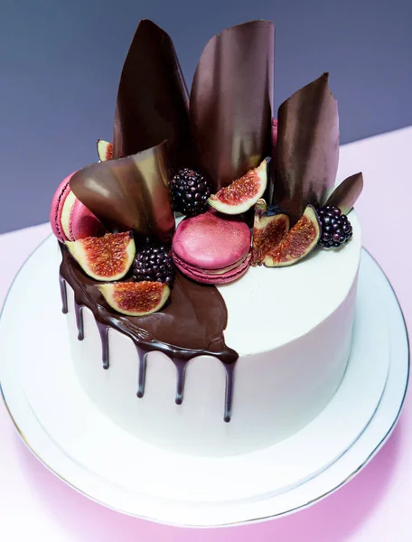 Cake decorated with chocolate waves, pink macaron and fresh figs — Stock Photo, Image