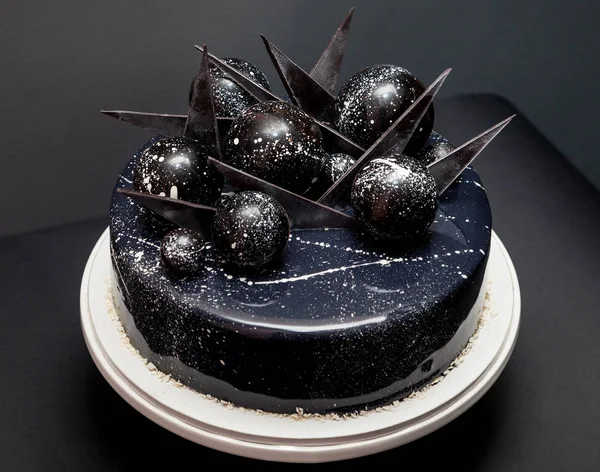 Bolo cósmico preto decorado com bolas de chocolate — Fotografia de Stock