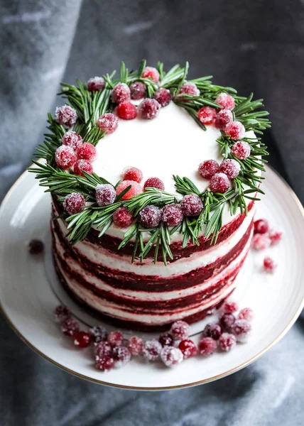 Christmas red velvet cake decorated with sugared cranberries and rosemary leaves