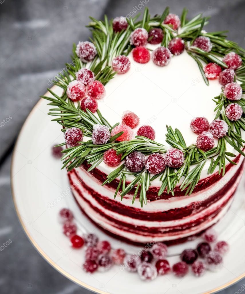 Christmas red velvet cake decorated with sugared cranberries and rosemary leaves