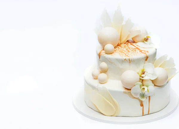 チョコレートのボールや新鮮な蘭の花で飾られた白のウエディング ケーキ — ストック写真