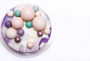 Menekşe mousse kek çikolata topları ile dekore edilmiştir.